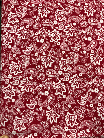 White paisley and flower design on red background